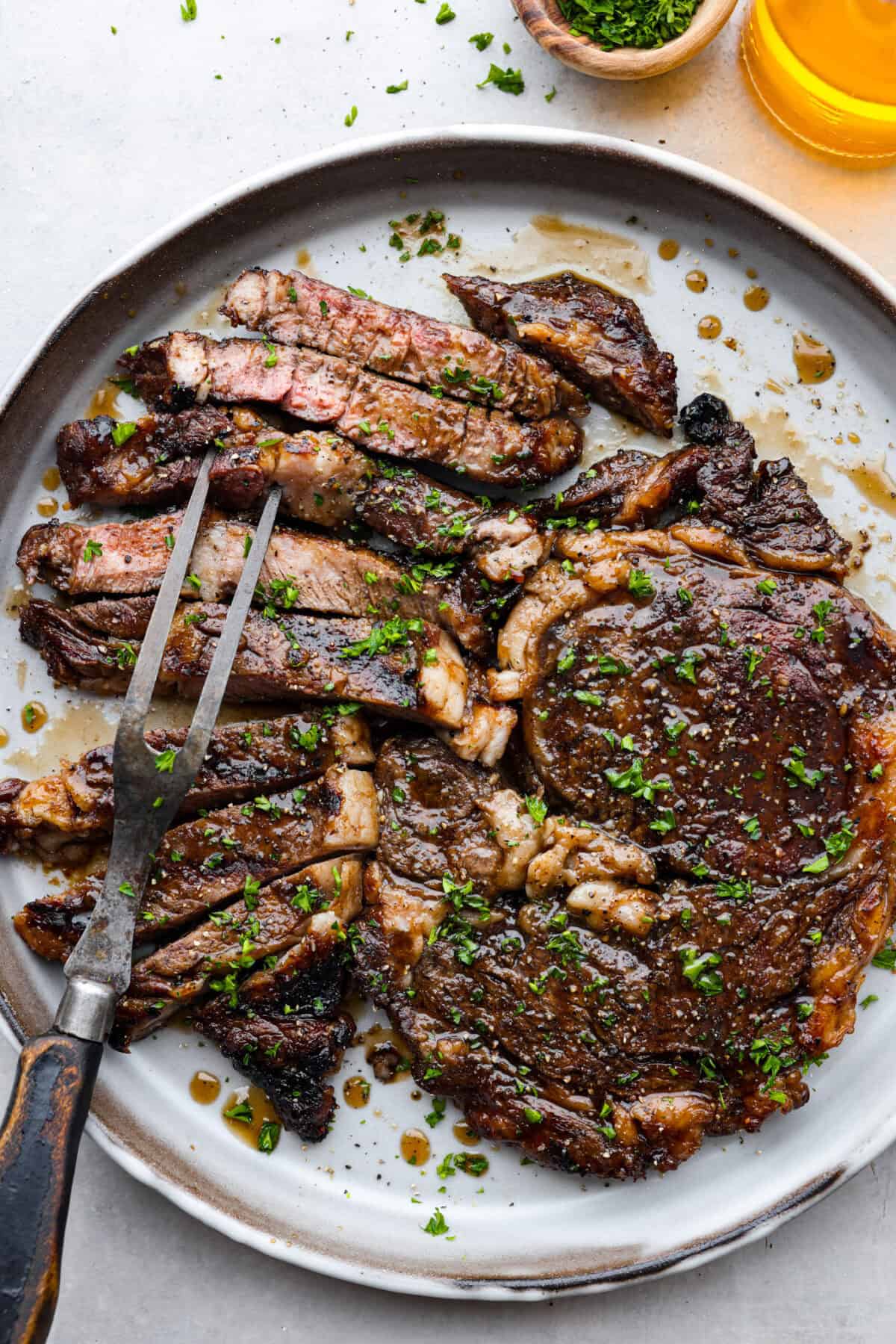 Fire up the grill for these mouthwatering Grilled Bourbon Steaks! Marinated in a blend of whiskey, brown sugar, and savory spices, these steaks are sure to be a hit at your next barbecue. Sliced bourbon steak on a plate.