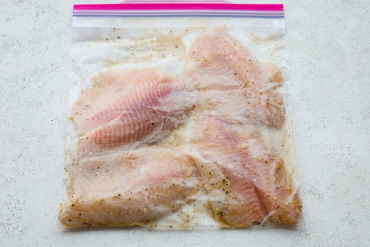 Fire up the grill! This grilled tilapia is deliciously seasoned and has the best flaky texture. Tilapia in a ziplock bag with marinade.
