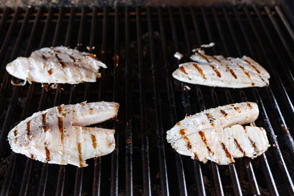 Fire up the grill! This grilled tilapia is deliciously seasoned and has the best flaky texture. Tilapia flipped on a grill.