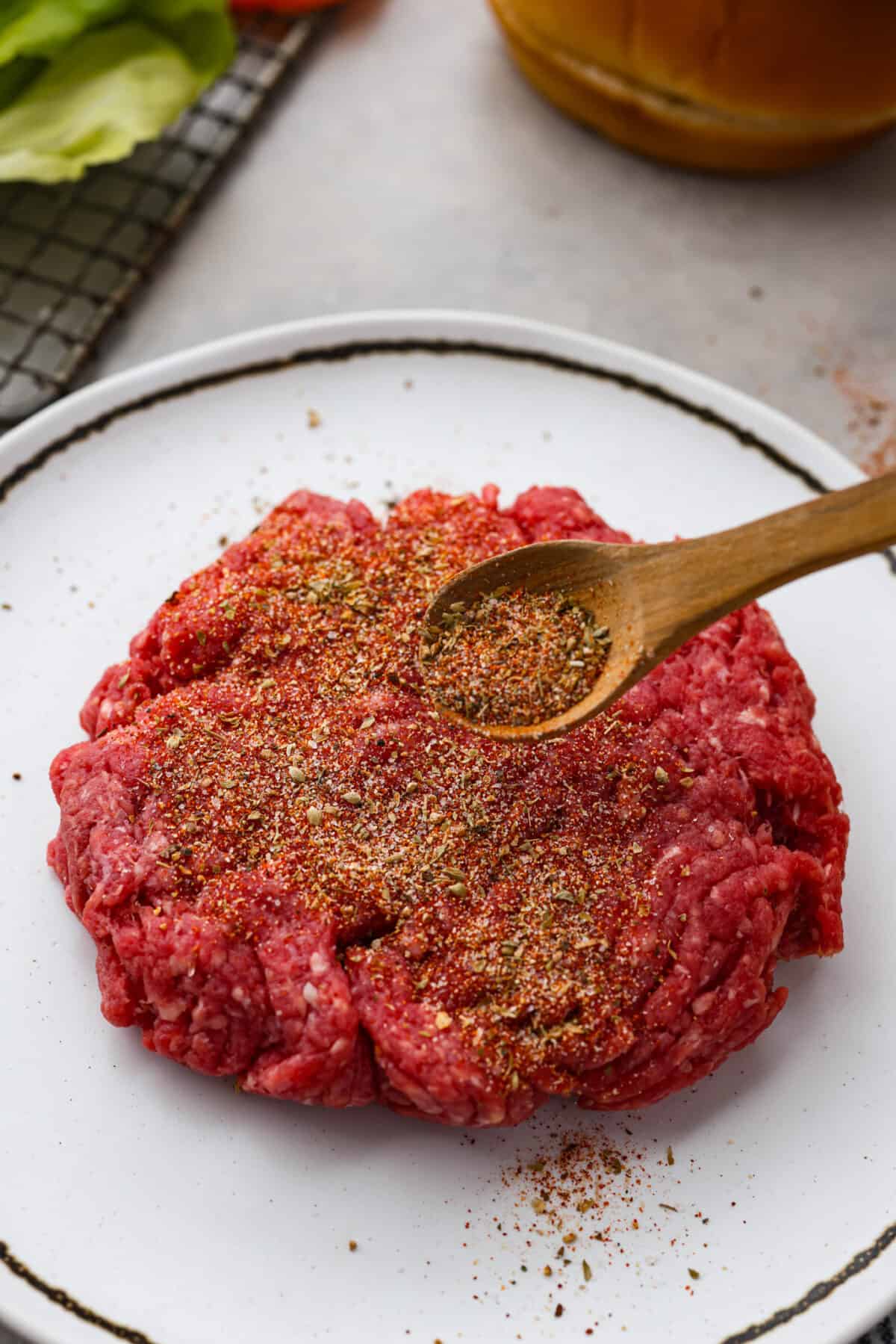This flavorful Burger Seasoning will take your favorite burger recipe to a new level of delicious! It’s a simple, yet tasty blend of staple spices and seasonings that makes each bite better than the next! Burger seasoning being sprinkled on ground beef.