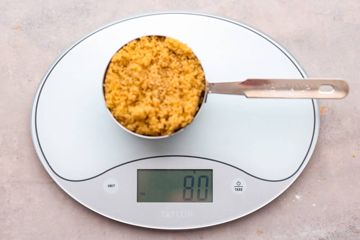 Whether you are a seasoned baker or just starting out, this informational post has all of my tips and tricks on how to properly measure baking ingredients. Unpacked brown sugar in a measuring cup on a scale.