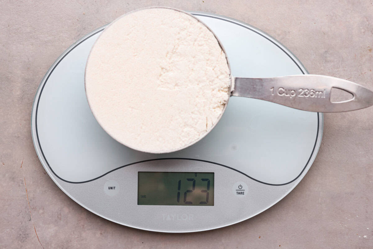 Whether you are a seasoned baker or just starting out, this informational post has all of my tips and tricks on how to properly measure baking ingredients. Flour in a measuring cup on a food scale.