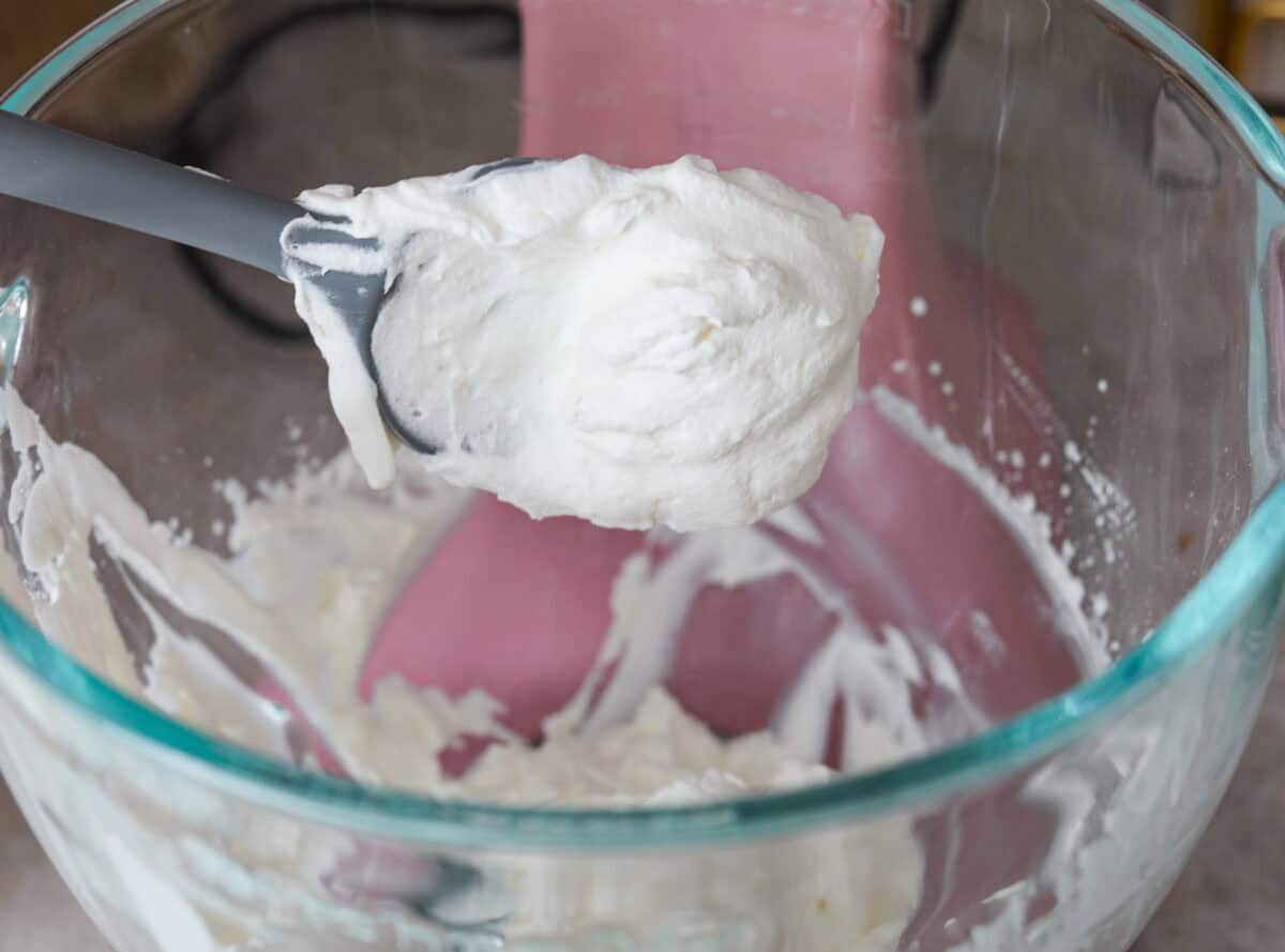 Key lime pie bars are classic key lime pie flavors baked into delightful little bars. They have a buttery graham cracker crust and a creamy lime filling. The sweet and zingy lime flavors make for an irresistible treat! Sixth photo of the whipped cream mixed in a stand mixer.