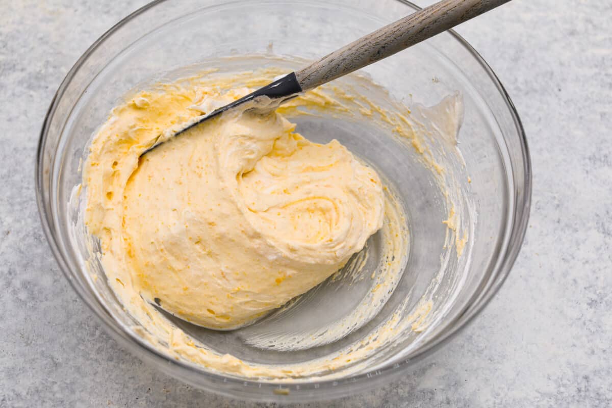 Lemon angel pie is a delightful dessert straight from heaven! It has a creamy lemon filling inside a sweet, airy meringue crust, then topped with fresh whipped cream. Every bite is pure bliss! Fourth process photo of whipped cream folded into the lemon filling.