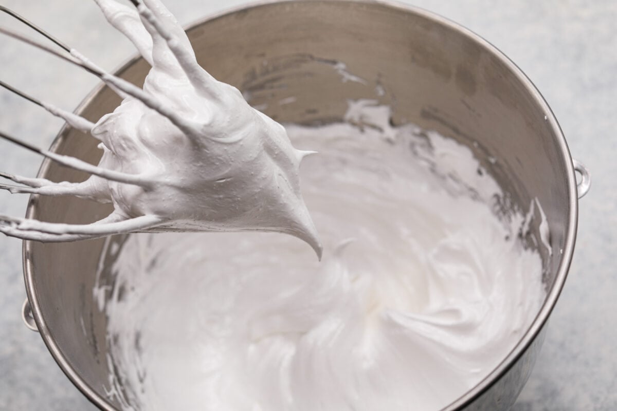 Lemon angel pie is a delightful dessert straight from heaven! It has a creamy lemon filling inside a sweet, airy meringue crust, then topped with fresh whipped cream. Every bite is pure bliss! First process photo of the meringue mixed to form stiff peaks.