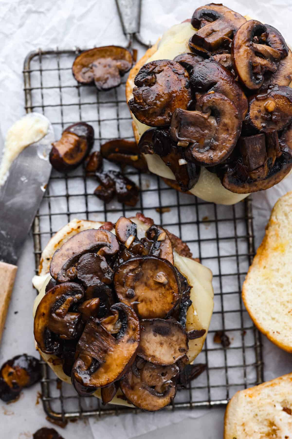 Create the most flavorful, juicy Mushroom Swiss Burger! Perfectly seasoned ground beef is topped with sautรฉed buttery mushrooms and melty Swiss cheese then loaded on fluffy buns for a gourmet burger that's easy to make at home! The top view of a mushroom burger without the top bun.
