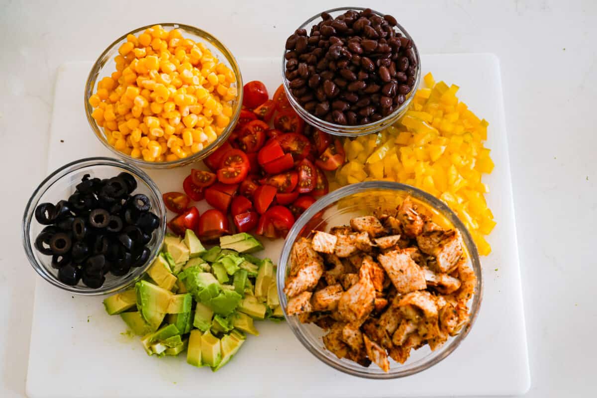 Santa Fe Salad is filled with bold southwestern flavor and has the most wonderful texture. Romaine lettuce, grilled chicken, black beans, corn, tomatoes, tortilla strips, avocado and cheese come together for the most amazing combination. And the creamy southwest dressing is the perfect finishing touch. The vegetables chopped and the chicken chopped and grilled.