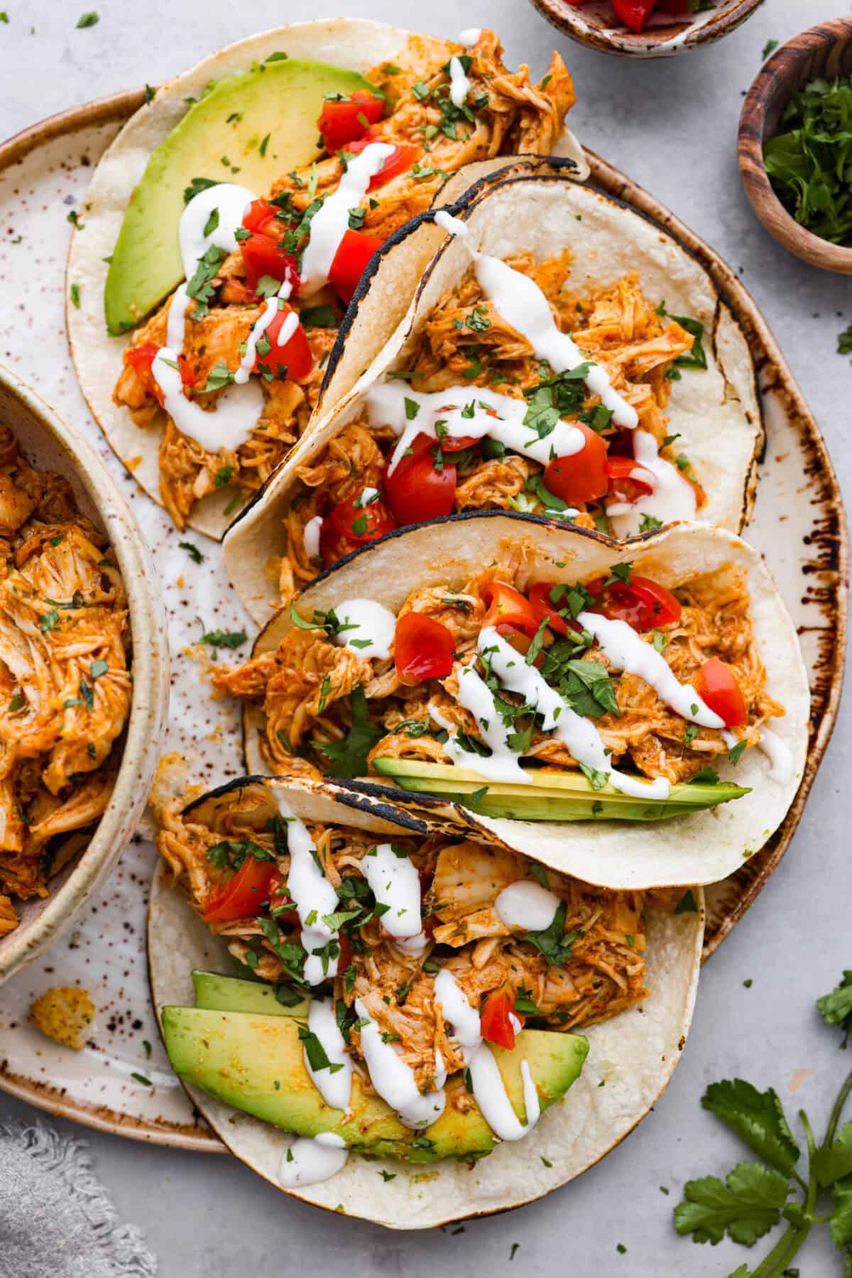 Switch up taco night with these 4-ingredient slow cooker ranch tacos! The chicken shreds perfectly and is packed with flavor. Dinner has never been easier! Top view of slow cooker ranch chicken tacos on a platter.
