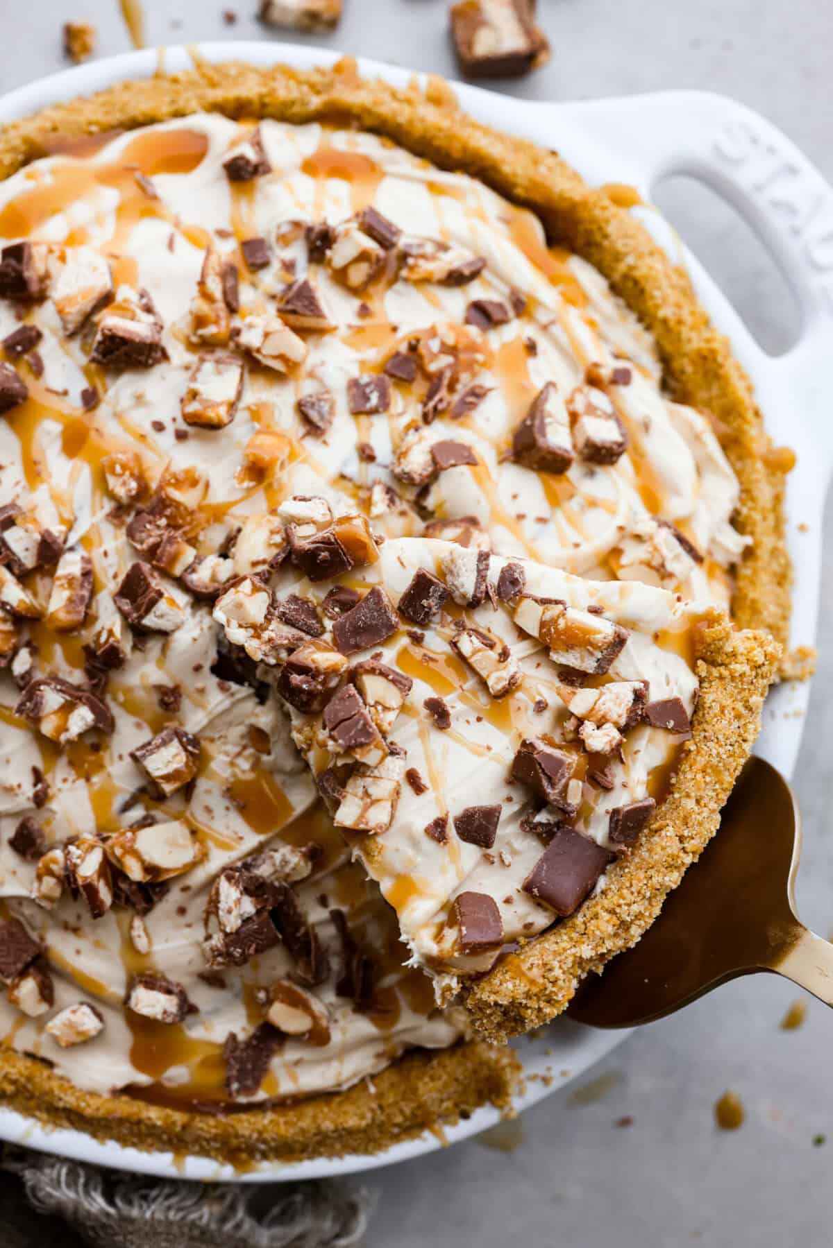 No Bake Snickers Bar Pie is one of the easiest and most delicious no bake pies that you make. You will love the Snickers pieces in every bite! A top view of no bake snickers bar pie.