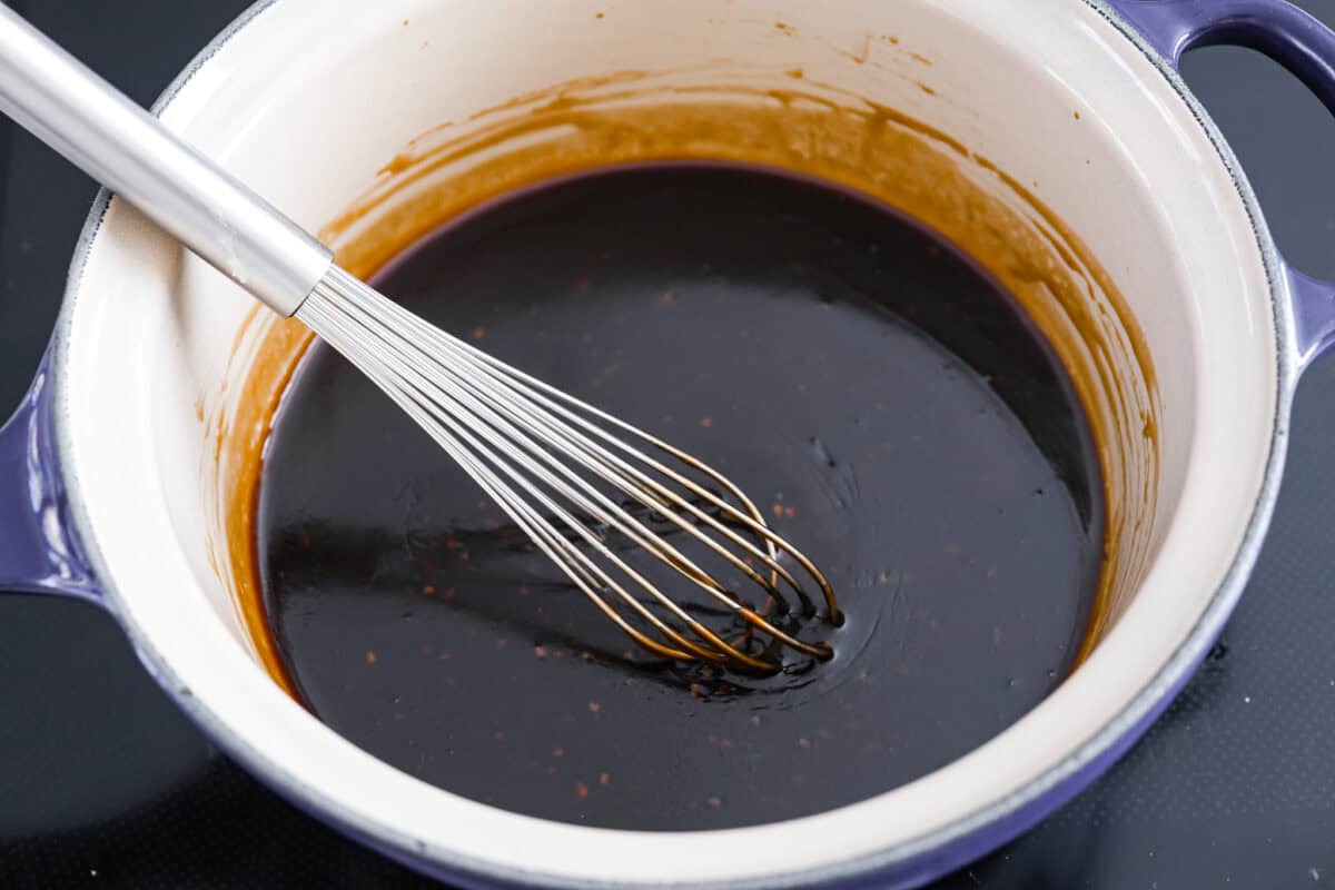 Teriyaki Sauce is super easy, takes only 10 minutes to make and is way better than store-bought! Made with simple ingredients, this is going to become a staple for your kitchen. A sauce pan with teriyaki sauce and a whisk.