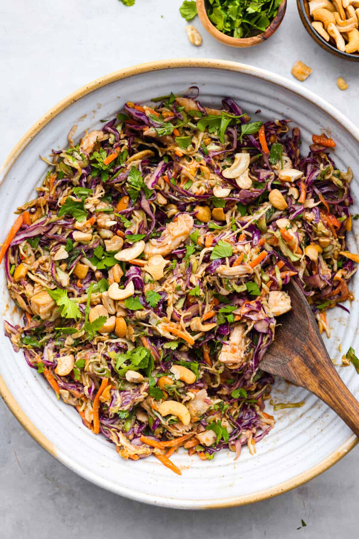 Crunchy and bright, this Thai Chicken Salad with creamy peanut dressing is bursting with flavor, texture and deliciousness! Prep it in under 30 minutes for an easy side dish or a delicious lunch! A bowl of Thai Chicken Salad.