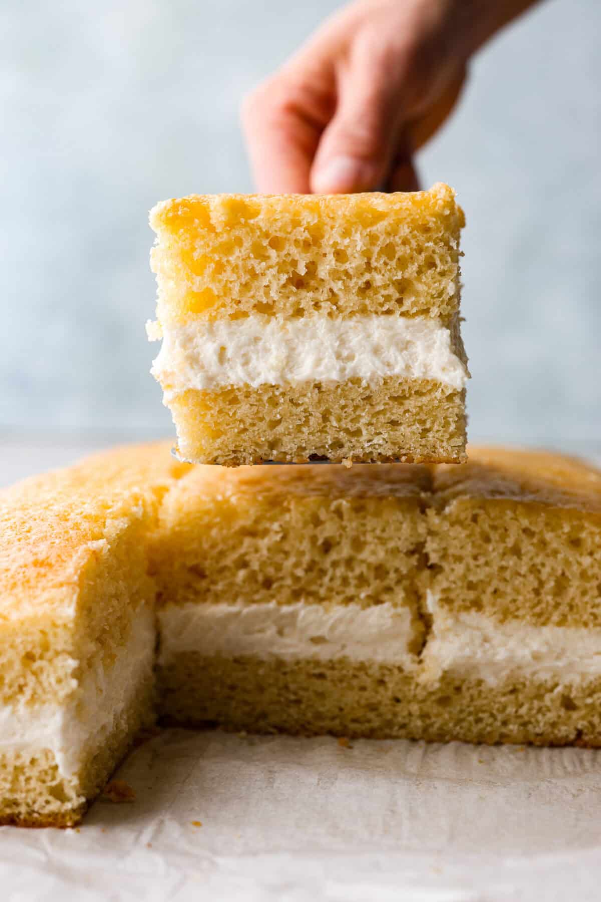 This Twinkie cake is a fun dessert that brings the classic snack cake to life. With its fluffy vanilla sponge and creamy filling, it's sure to be a hit with everyone! Side view of a slice of Twinkie cake.