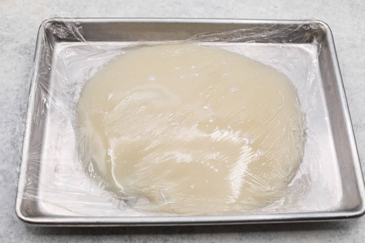 This Twinkie cake is a fun dessert that brings the classic snack cake to life. With its fluffy vanilla sponge and creamy filling, it's sure to be a hit with everyone! Top view of flour mixture on a baking sheet covered in plastic wrap.