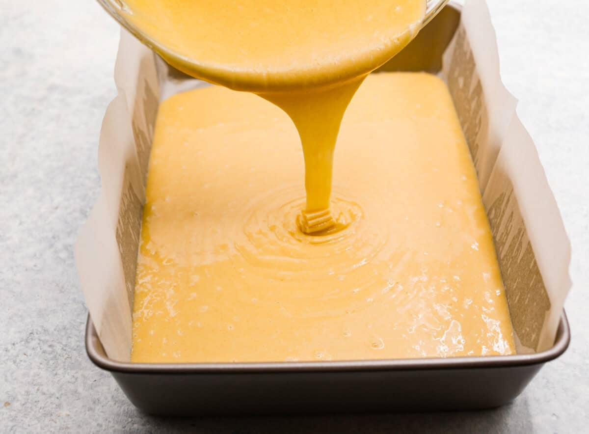 This Twinkie cake is a fun dessert that brings the classic snack cake to life. With its fluffy vanilla sponge and creamy filling, it's sure to be a hit with everyone! Batter being poured into a cake pan.