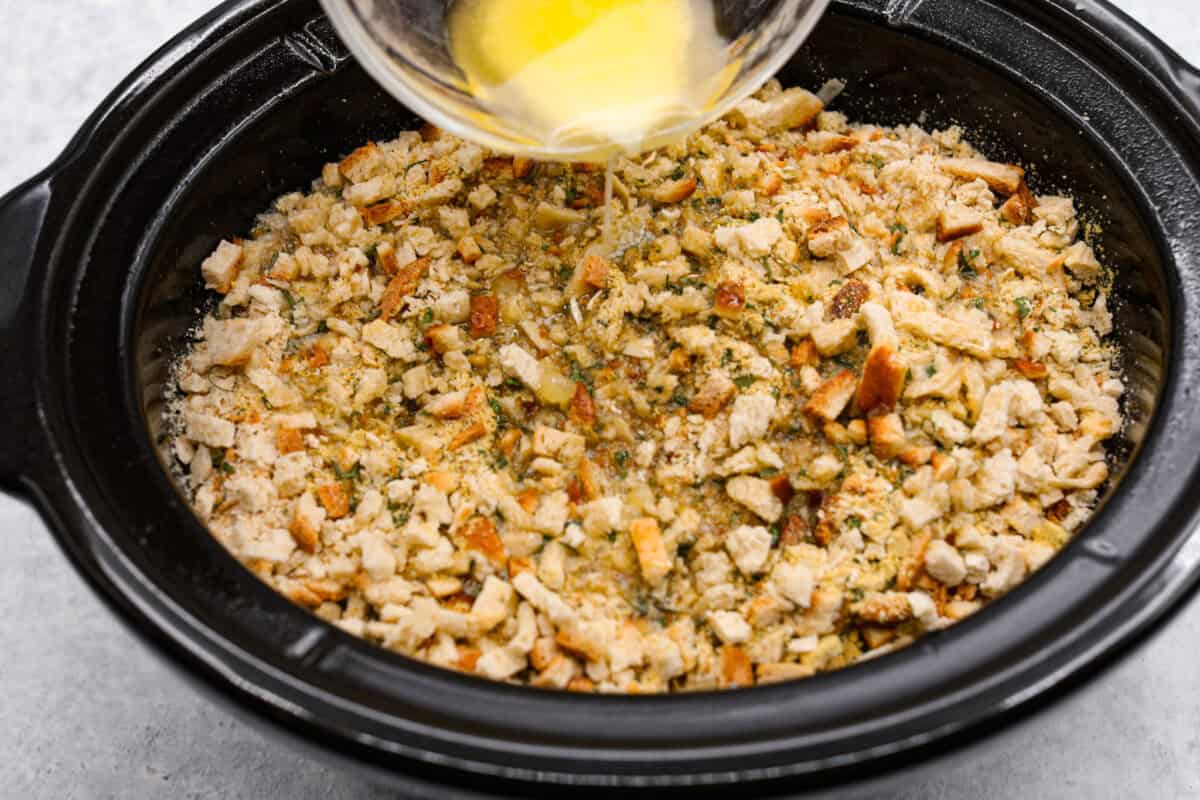 Treat yourself to this easy, Slow Cooker Chicken Cordon Bleu recipe! With tender chicken, savory ham, and melty Swiss cheese, it's a perfect comfort meal for any day. Melted butter being drizzled on top of a chicken cordon bleu mixture.
