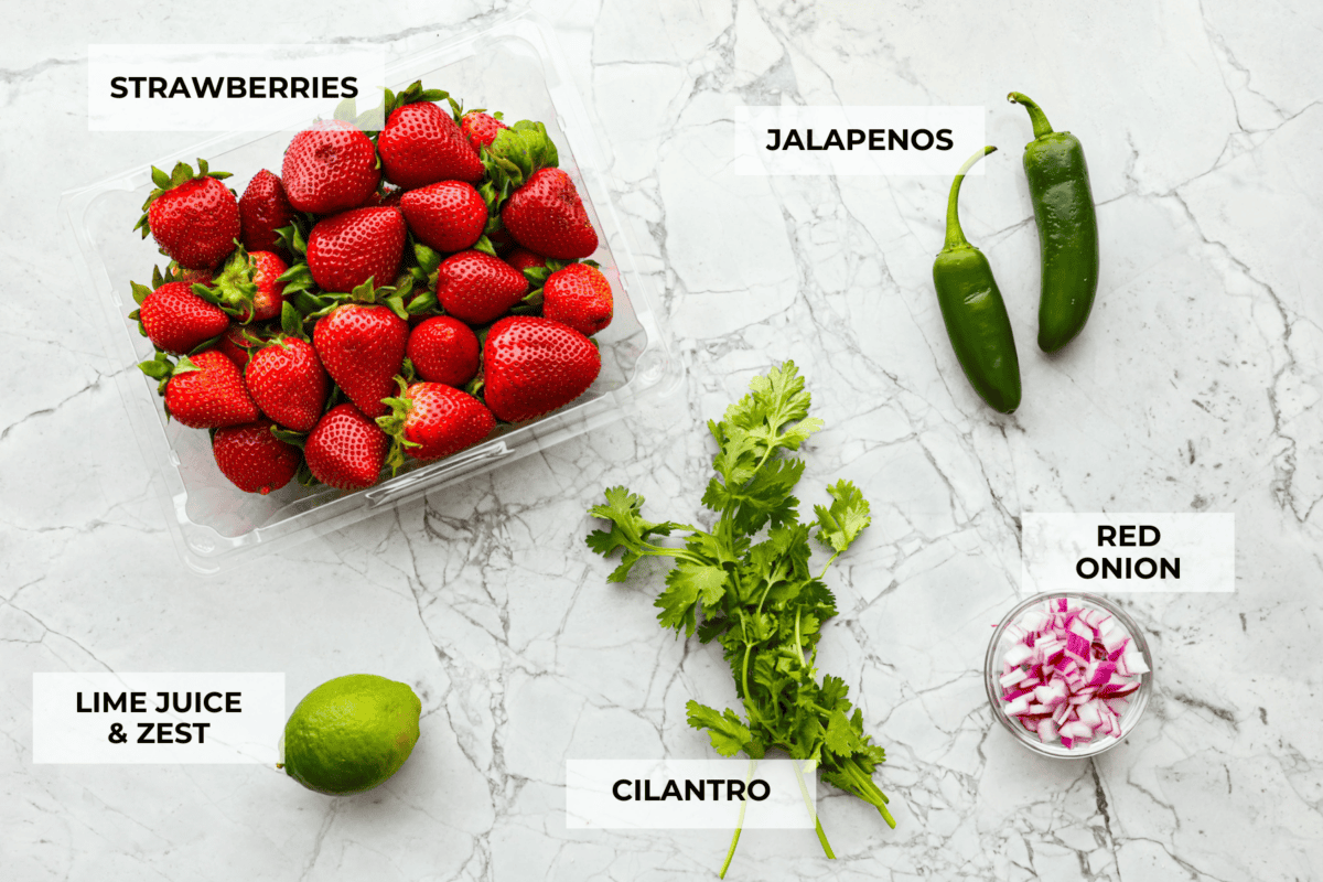 Add a burst of fresh, fruity flavor to your table with this Strawberry Salsa. This quick and easy recipe combines sweet strawberries with a hint of spice and is perfect for a light and refreshing snack in just 10 minutes! Top view of individual ingredients on a counter with labels.