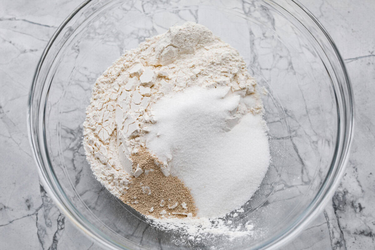 Whip up a batch of these delightful zeppole, perfect for a sweet treat anytime! With a light, fluffy texture and a generous coating of powdered or cinnamon sugar, these Italian donuts are sure to please. Overhead shot of a glass bowl with dry ingredients.