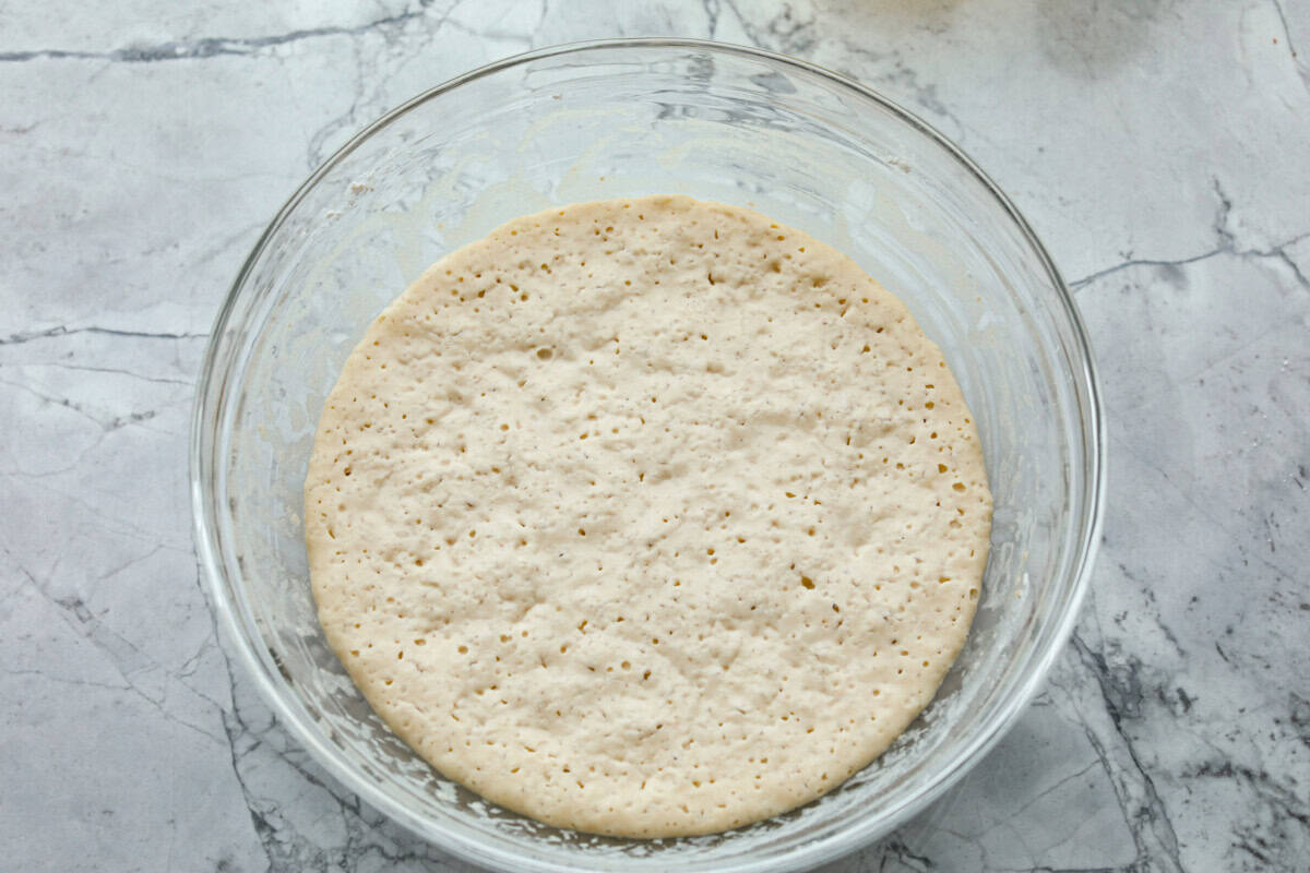 Whip up a batch of these delightful zeppole, perfect for a sweet treat anytime! With a light, fluffy texture and a generous coating of powdered or cinnamon sugar, these Italian donuts are sure to please. Overhead shot of dough resting in glass bowl