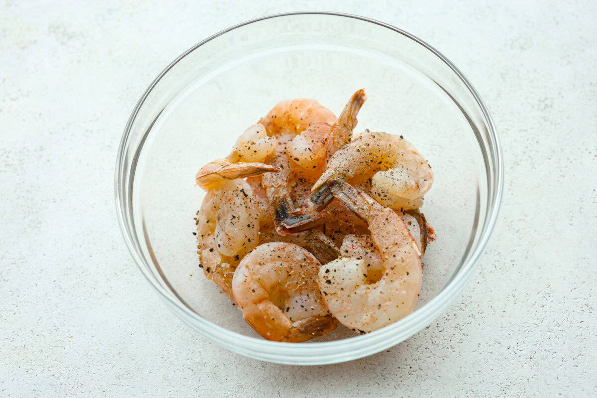 This air fryer shrimp is tender, delicious, and so easy to make! With only a few ingredients, the marinated shrimp cooks to perfection and has the best flavor! First photo of the shrimp seasoned with salt and pepper.