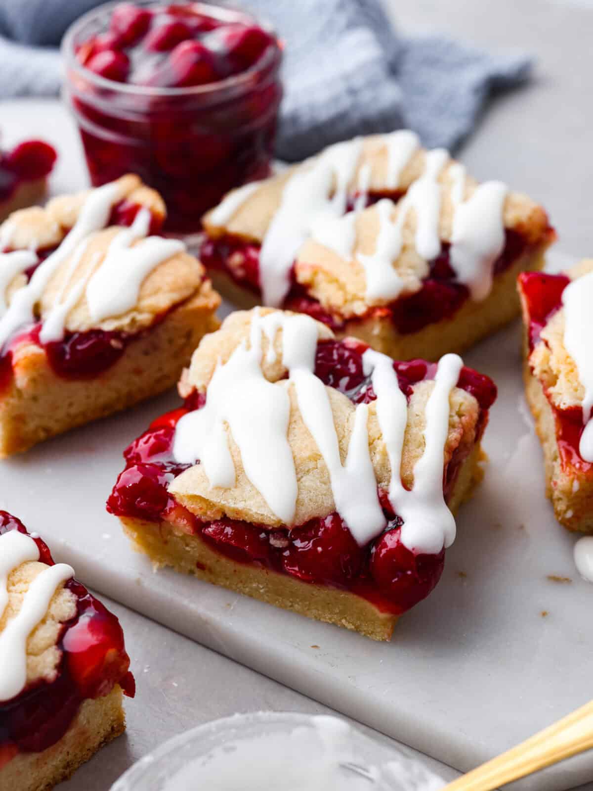 Enjoy cherry pie in its best form: cherry pie bars! You can whip up a whole pan in minutes using cherry pie filling. They’re beautiful, easy to make, and always a crowd-pleaser! A close up of cherry pie bars.
