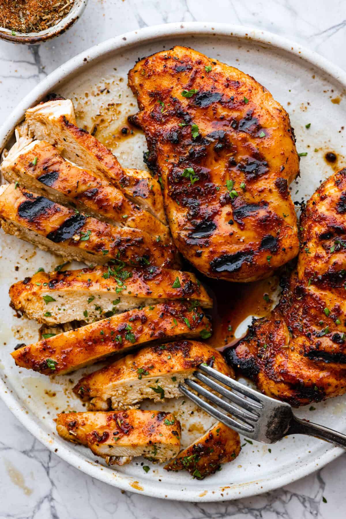 Fire up your grill because these grilling basics will give you all the confidence you need! Discover how easy it is to cook, entertain, and make incredible food on an outdoor grill. Top view of grilled chicken on a platter.