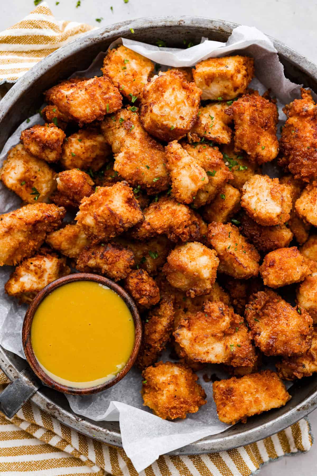 These Chick-fil-A Nuggets taste just like the real thing! They are crispy and salty with the slightest hint of sweetness.ย Pair them with the Chick-fil-A sauce and make the perfect family meal! Chicken nuggets on a platter with some chick oil a sauce.