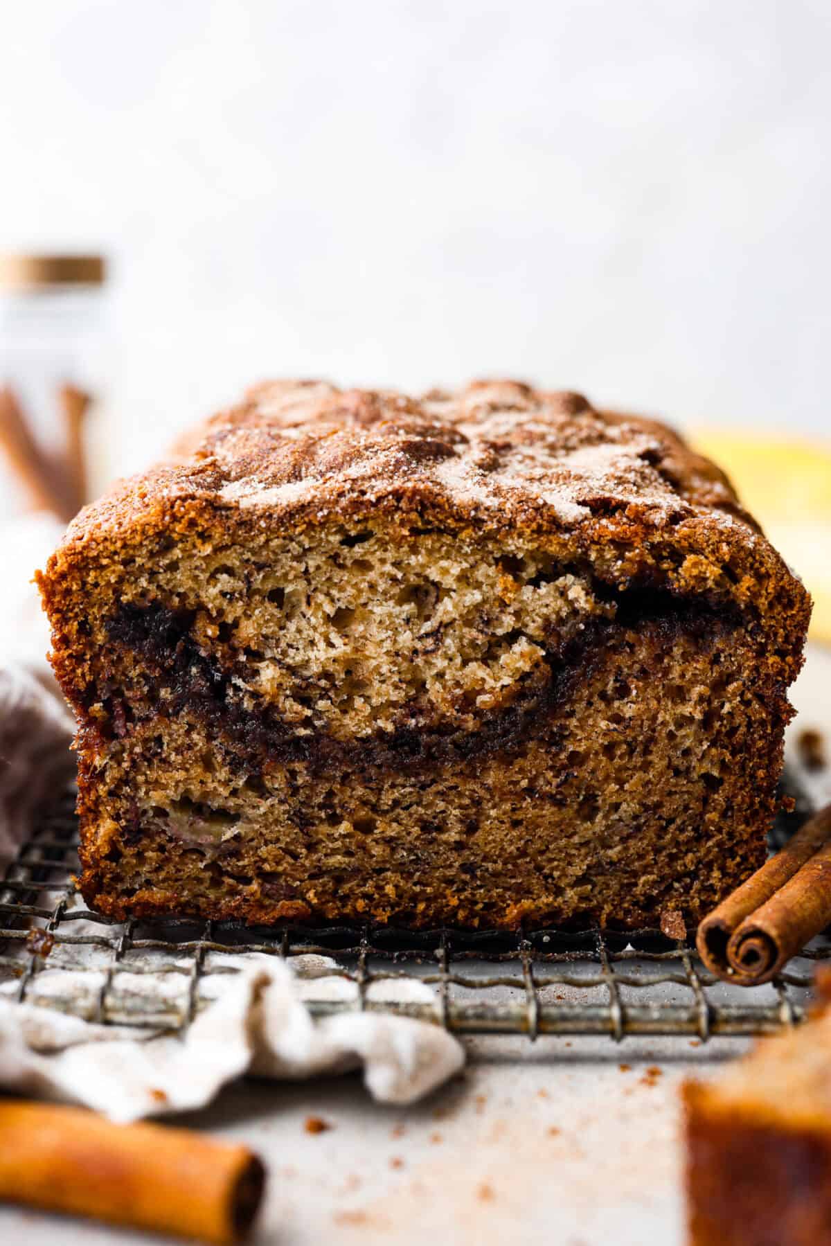 Cinnamon Swirl Banana Bread is a delightful twist on the classic. What sets this recipe apart is the luscious cinnamon sugar swirl running through the middle and on top, creating a beautiful marbled effect and an extra burst of flavor. It's irresistibly delicious! Side shot of the cut through the middle of the banana cinnamon swirl loaf.