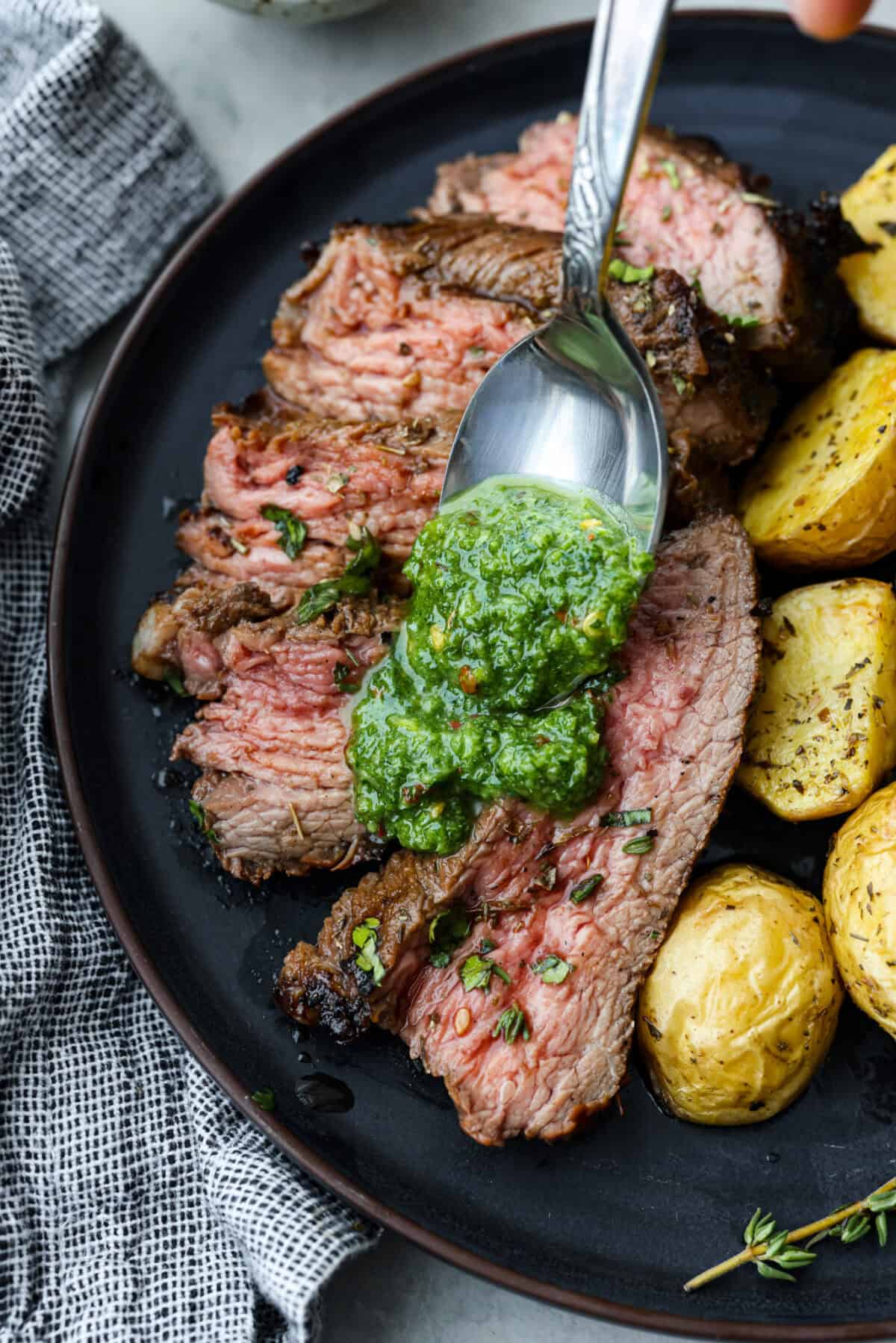 Close up shot of raw tri-tip in large zip-loc with marinade being poured over it. Overhead shot of chimichurri sauce being poured over slices of meat on a plate.