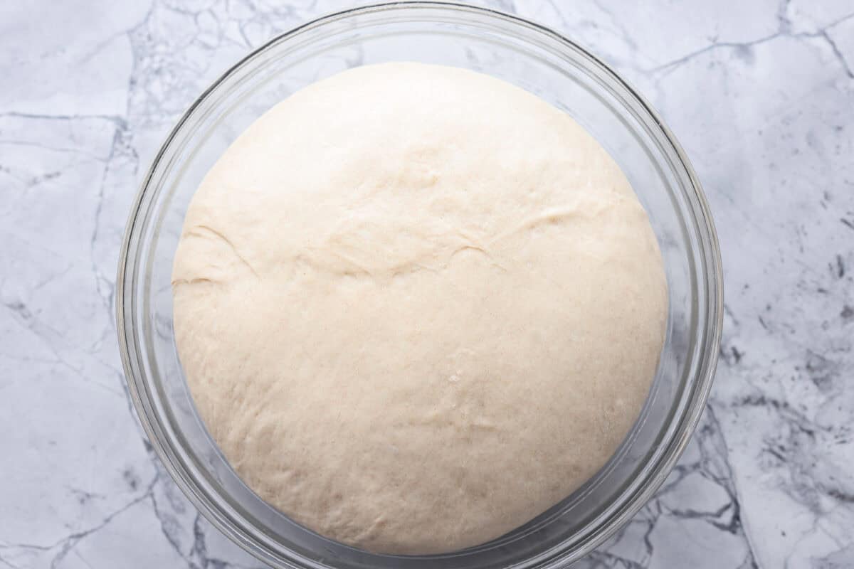 You want to make bread, but where do you start? My beginner's guide to baking bread is here to save the day! Feel confidentย at bread-making while I hold your hand through the whole process. Third photo of the first ride of dough in a bowl.