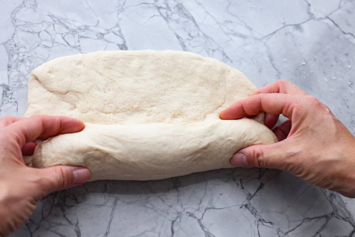 You want to make bread, but where do you start? My beginner's guide to baking bread is here to save the day! Feel confidentย at bread-making while I hold your hand through the whole process. Fifth photo of shaping the dough.
