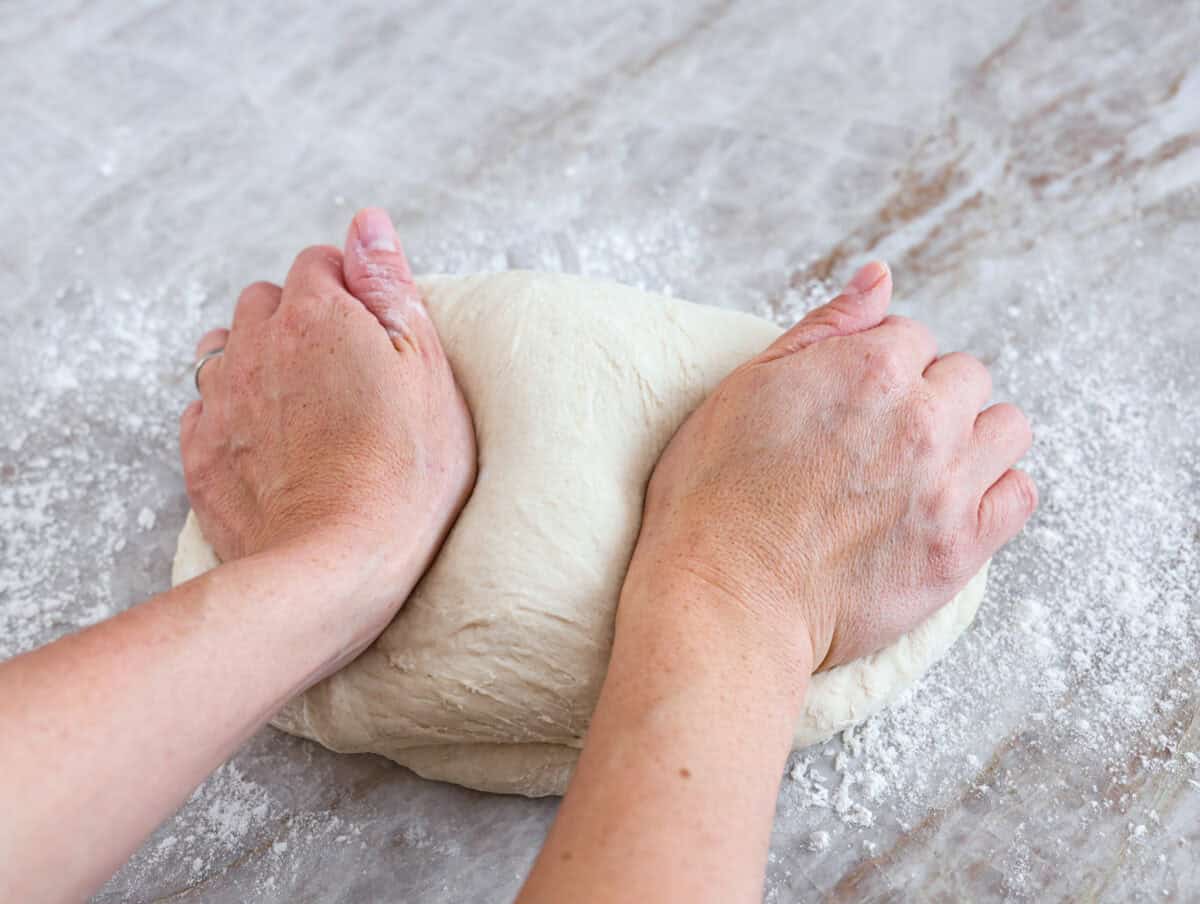 You want to make bread, but where do you start? My beginner's guide to baking bread is here to save the day! Feel confidentย at bread-making while I hold your hand through the whole process. Close view of kneading dough by hand.