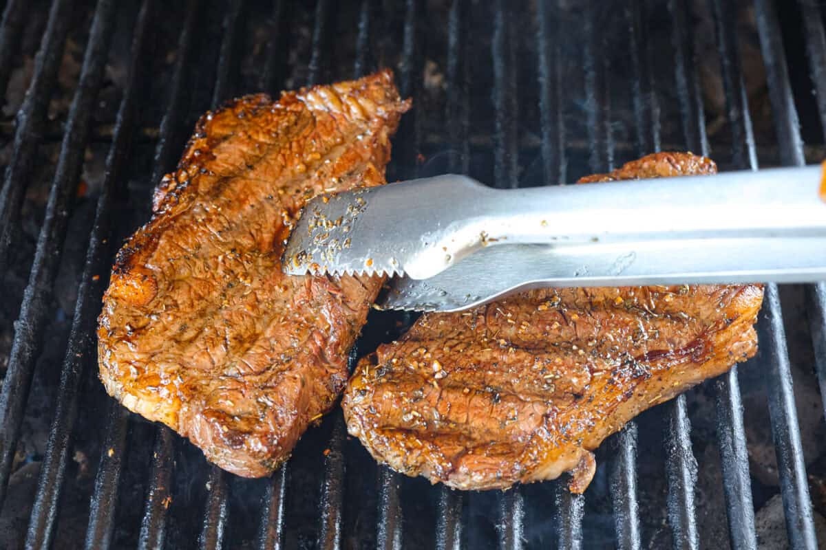 Fire up your grill because these grilling basics will give you all the confidence you need! Discover how easy it is to cook, entertain, and make incredible food on an outdoor grill. First photo of tongues flipping the steak.