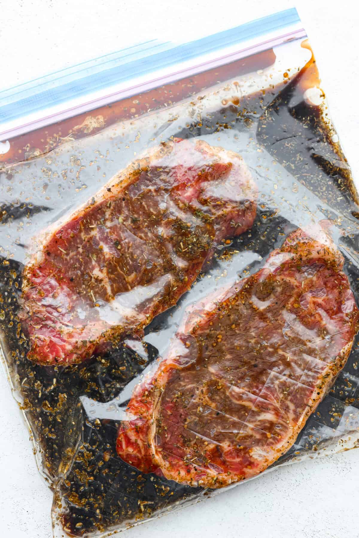 Fire up your grill because these grilling basics will give you all the confidence you need! Discover how easy it is to cook, entertain, and make incredible food on an outdoor grill. First photo of steaks marinating.