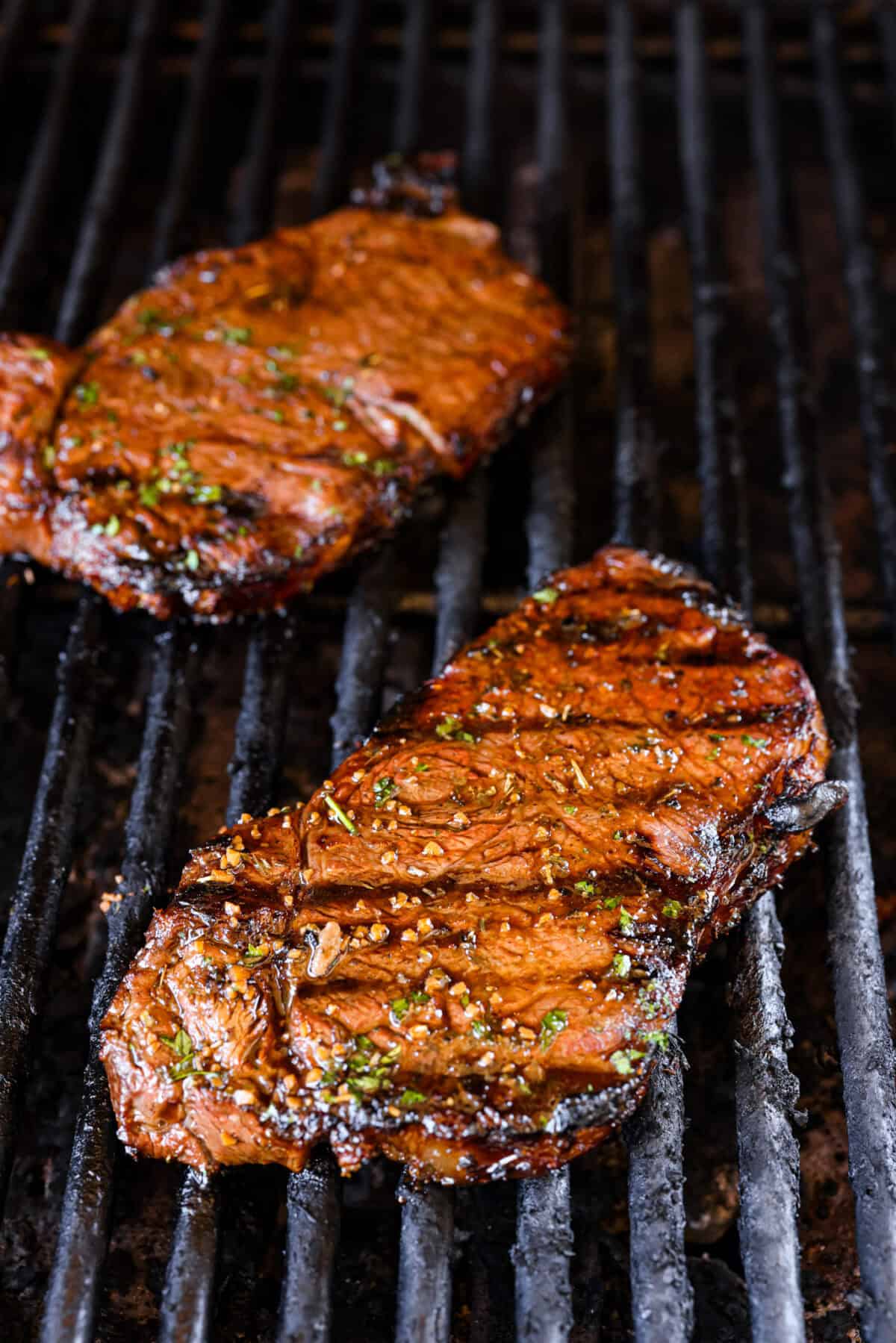 Fire up your grill because these grilling basics will give you all the confidence you need! Discover how easy it is to cook, entertain, and make incredible food on an outdoor grill. Close view of a grilled steak on the grill.
