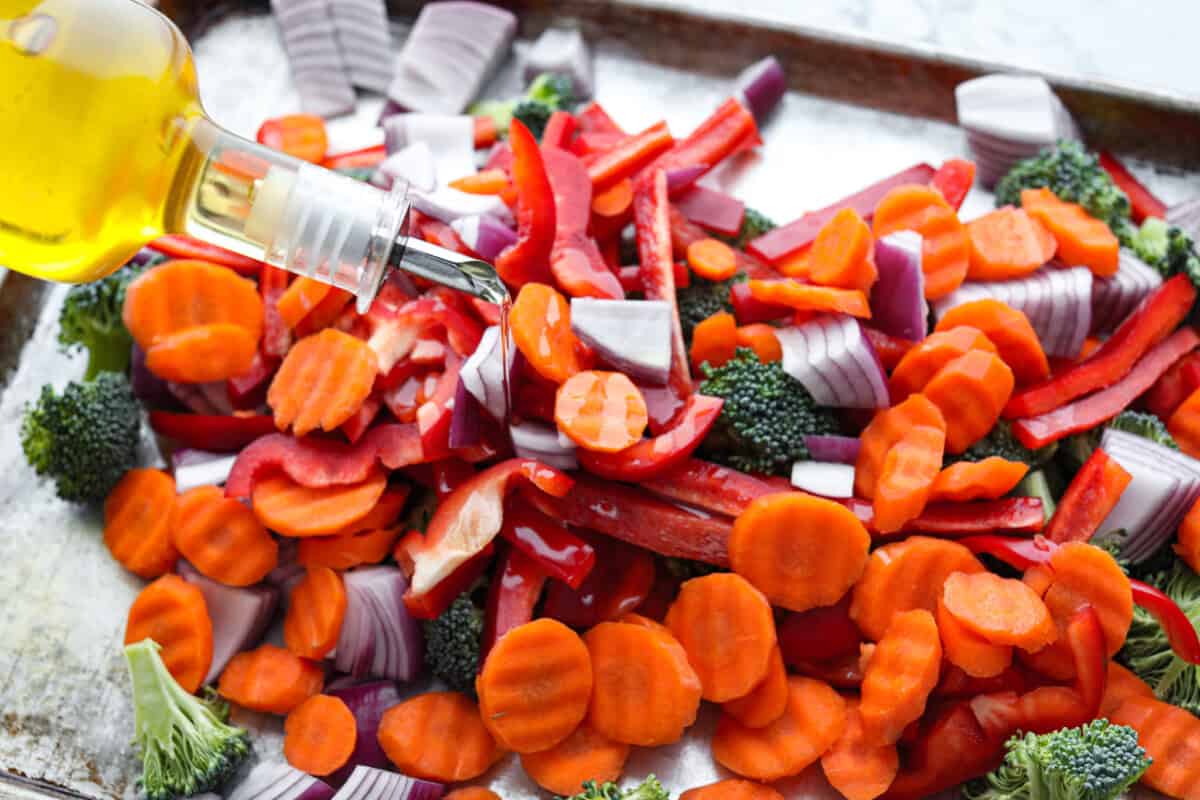 This sheet pan teriyaki chicken with vegetables is a family favorite! It's loaded with tender chicken and veggies that get tossed in a homemade teriyaki sauce. A one pan dinner recipe that is super easy to throw together. Second photo of vegetable cut and drizzled with oil.