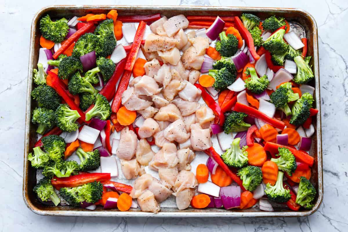 This sheet pan teriyaki chicken with vegetables is a family favorite! It's loaded with tender chicken and veggies that get tossed in a homemade teriyaki sauce. A one pan dinner recipe that is super easy to throw together. Fourth photo of the vegetables and chicken on the sheet pan.