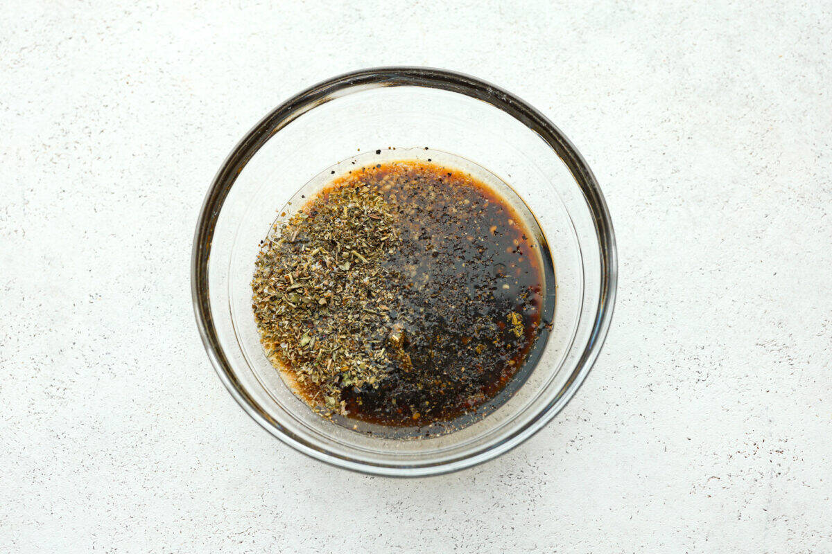 Grilled Tri-Tip is a flavorful, juicy steak that will be the star of your barbecue! It's marinated in a simple, yet tasty marinade, then grilled to perfection. Serve with my sweet and savory chimichurri sauce and your favorite sides for an impressive meal that everyone will love! Overhead shot of marinade ingredients in a glass bowl.