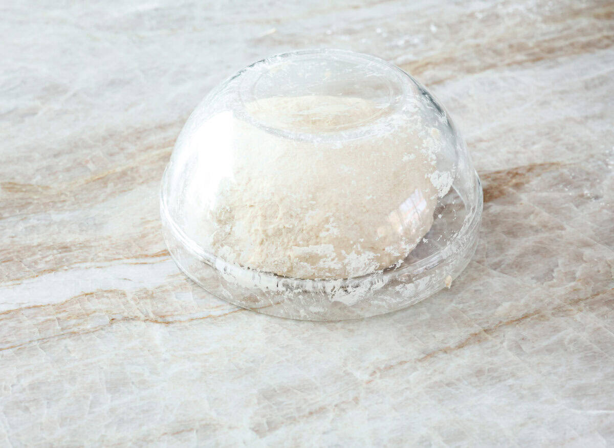 This is the perfect beginner's guide for making wood-fired pizza dough! Pizza expert, Chef Brandon Price, taught me how to make authentic homemade pizza, and now you get to learn too! Sixth photo of a glass bowl over the dough to allow it to rest.