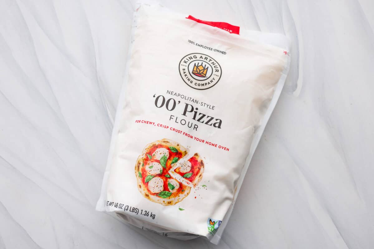 This is the perfect beginner's guide for making wood-fired pizza dough! Pizza expert, Chef Brandon Price, taught me how to make authentic homemade pizza, and now you get to learn too! First photo of '00' pizza flour in the bag.