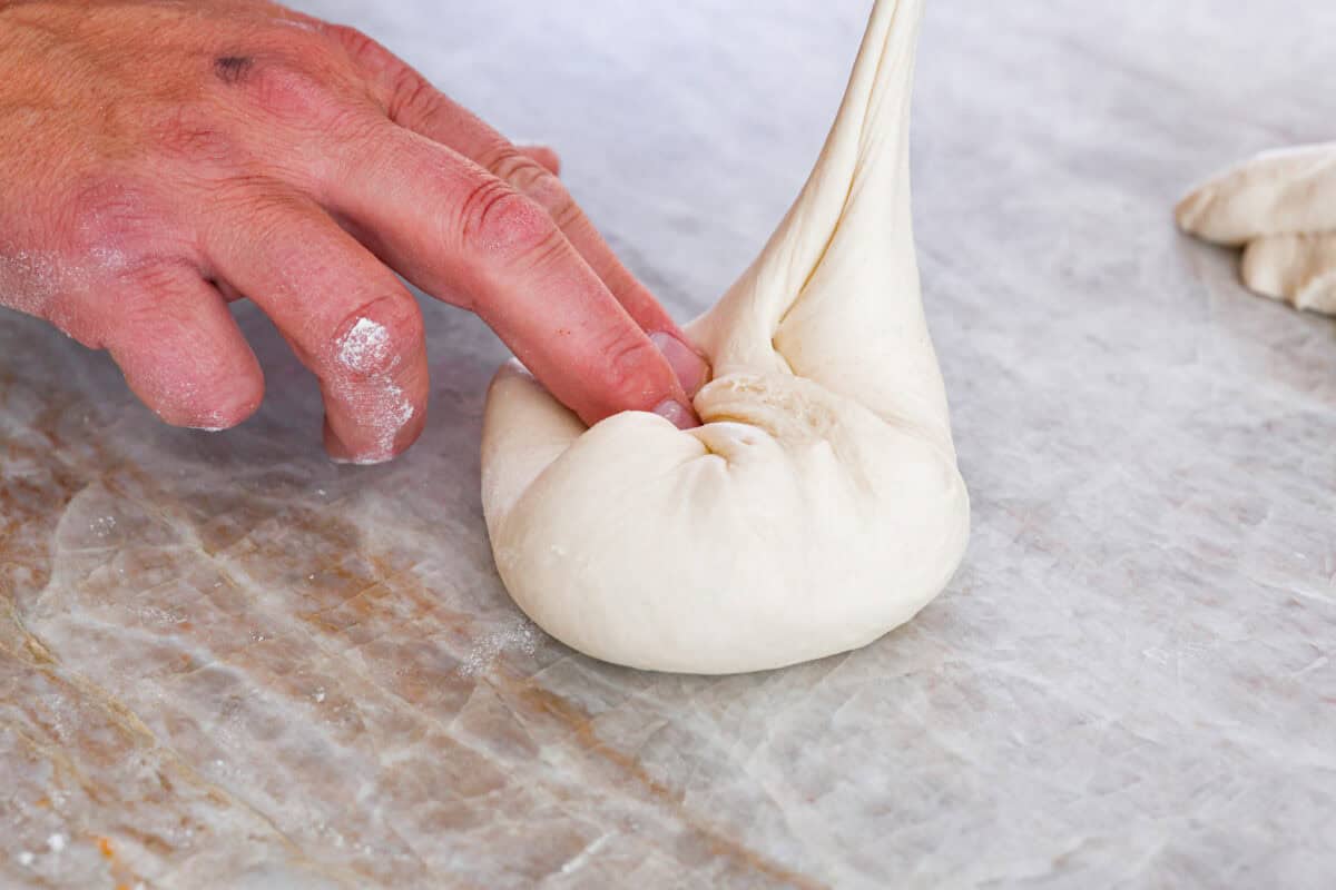 TThis is the perfect beginner's guide for making wood-fired pizza dough! Pizza expert, Chef Brandon Price, taught me how to make authentic homemade pizza, and now you get to learn too! First photo of dividing and shaping the dough into balls.