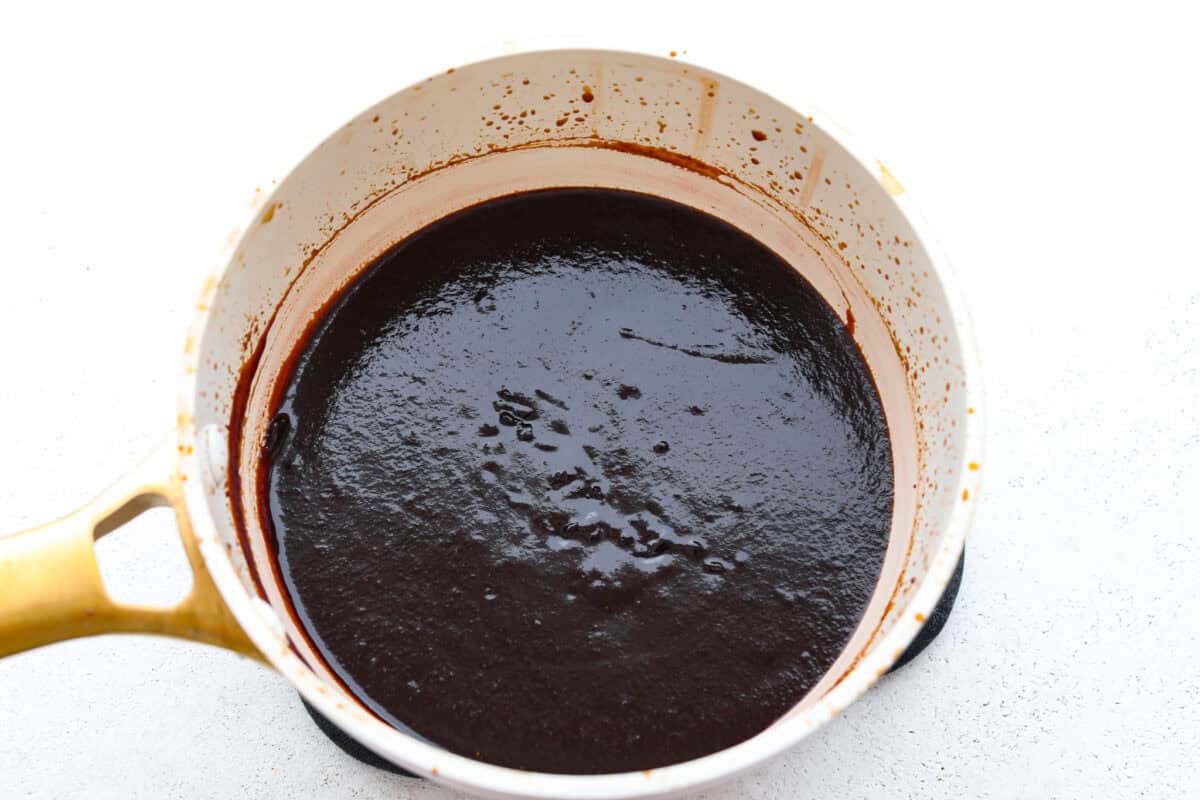 This Homemade BBQ Sauce recipe has the most amazing flavor combination and only takes minutes to make! It's sweet and tangy and has the perfect amount of smokiness that makes this BBQ sauce a family favorite! Second photo of the bbq sauce cooked and thickened.