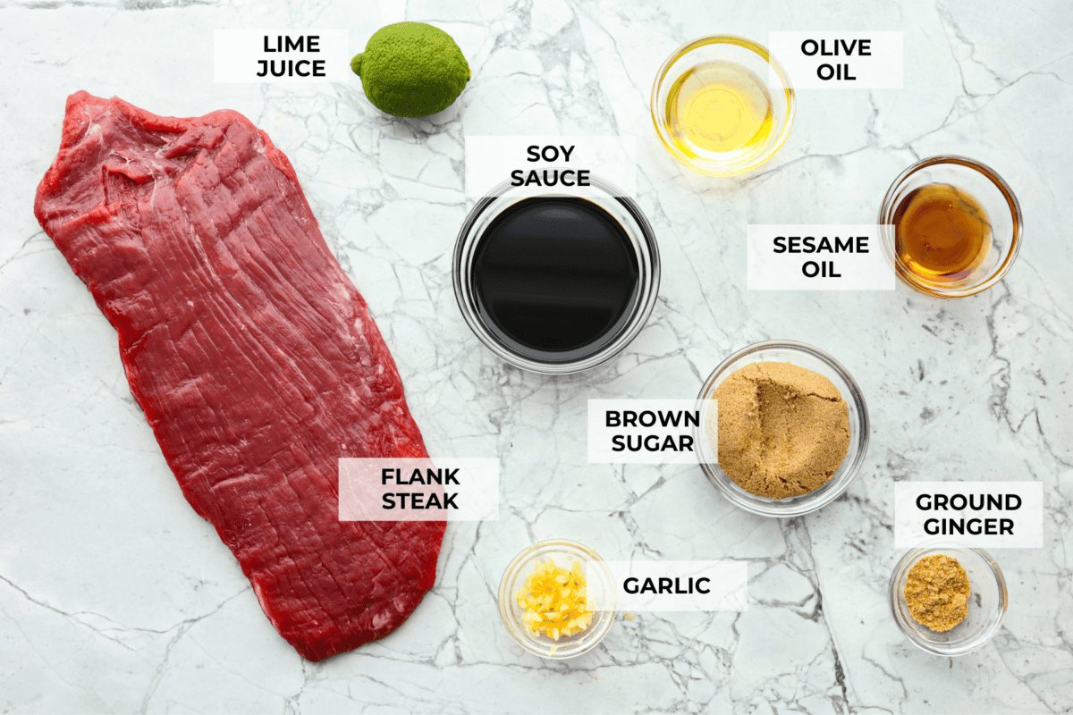 This grilled flank steak with Asian-inspired marinade features a savory blend of soy sauce, ginger, and garlic. The steak is seared to perfection on a hot grill, locking in all the delicious flavors. Best of all, itโs ready in less than 10 minutes! Overhead shot of labeled ingredients for marinade.
