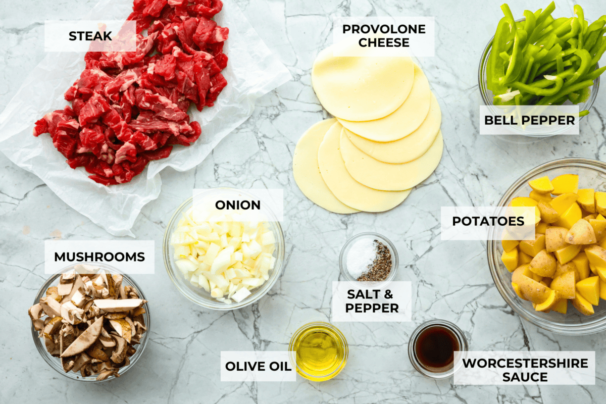Try these delicious Philly Cheesesteak Foil Packs, a fun new way to enjoy the flavors of the classic Philly Cheesesteak. Tender beef, veggies, and melty cheese are grilled or baked together for a wonderful crowd-pleasing meal everyone will love! Overhead shot of labeled ingredients in individual bowls.