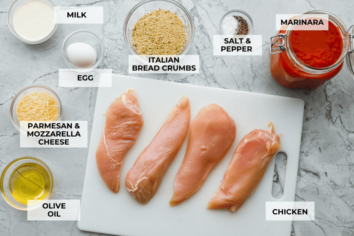 This simple slow-cooker chicken parmesan is full of delicious Italian flavors, oozy cheese, and mouthwatering marinara sauce. You'll be able to throw everything in the crock pot, set it, and forget it—dinner is served! Overhead shot of labeled ingredients.