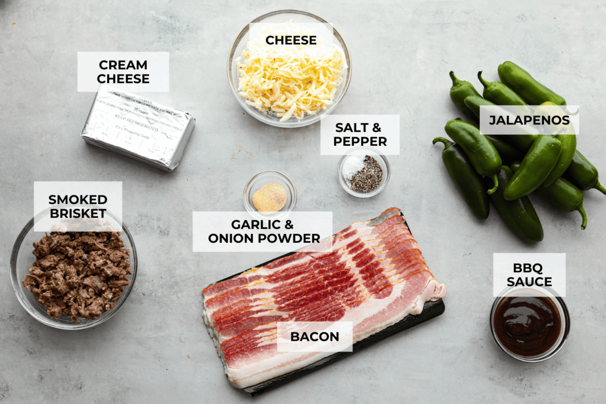 Texas Twinkies are a major upgrade to your classic jalapeรฑo poppers! They're jalapeรฑos filled with cream cheese, brisket, and shredded cheese, then wrapped in bacon and cooked to perfection. These are the hit of any party! Overhead shot of labeled ingredients.
