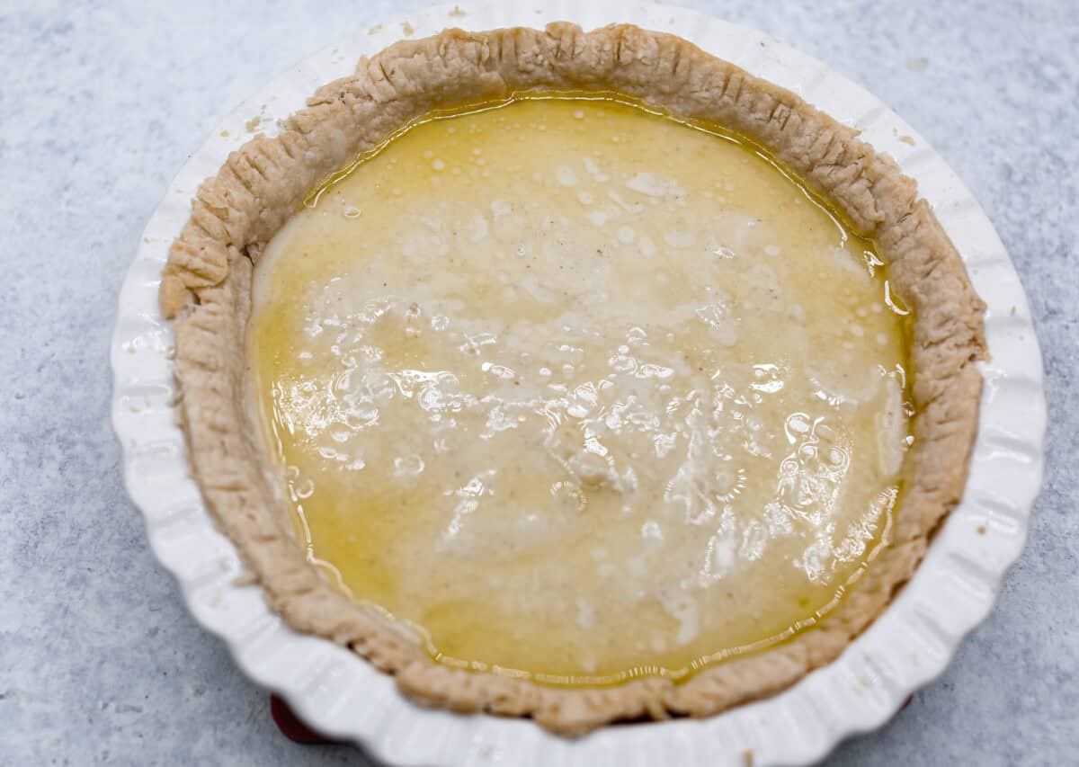 Sugar cream pie, or Hoosier pie, is a creamy, delicious treat with deep roots in the Midwest, especially in Indiana. You can top it however you like, serve it warm, at room temperature, or even chilled. Give this simple recipe a go. I know youโll love it! Overhead shot of pie crust in pie pan, filled with pie filling, with melted butter over the top.