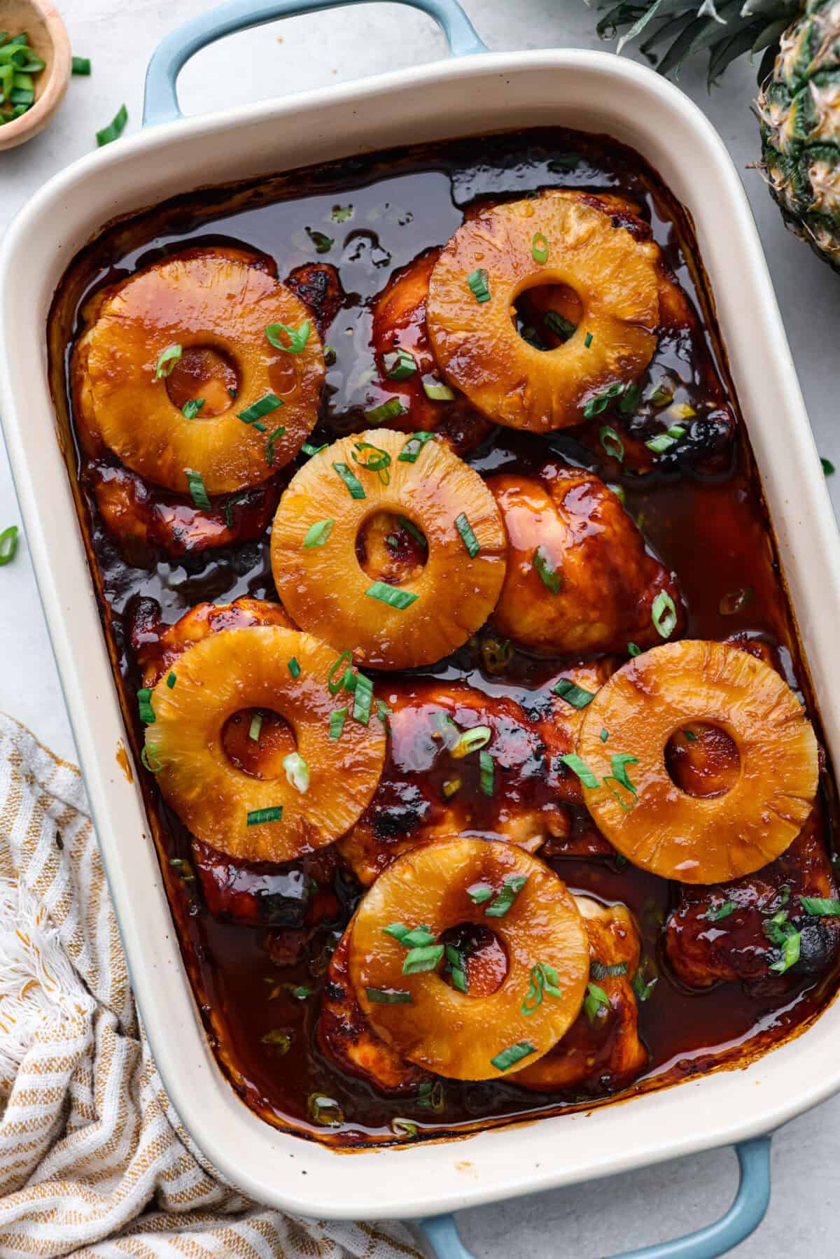 Baked Huli Huli chicken is a tried and true recipe now made in the oven! Tender chicken baked in a sweet and savory sauce. This easy one-pan dinner is full of Hawaiian-inspired flavors! Top view of baked Huli Huli chicken in a baking dish.
