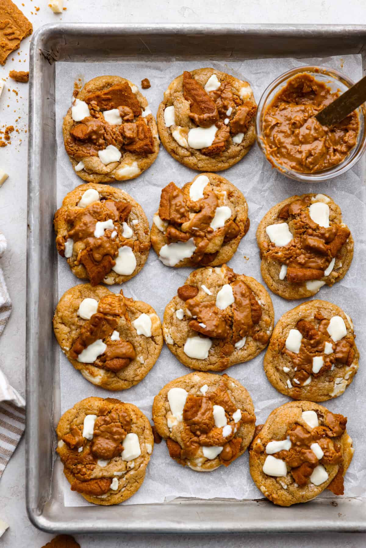 Satisfy your sweet tooth with loaded Biscoff Cookies. They are soft and chewy and infused with the flavor of Biscoff cookies and cookie butter. These are easy to whip up and will be a hit for any occasion! Overhead shot of baked Biscoff cookies on a cookie sheet.