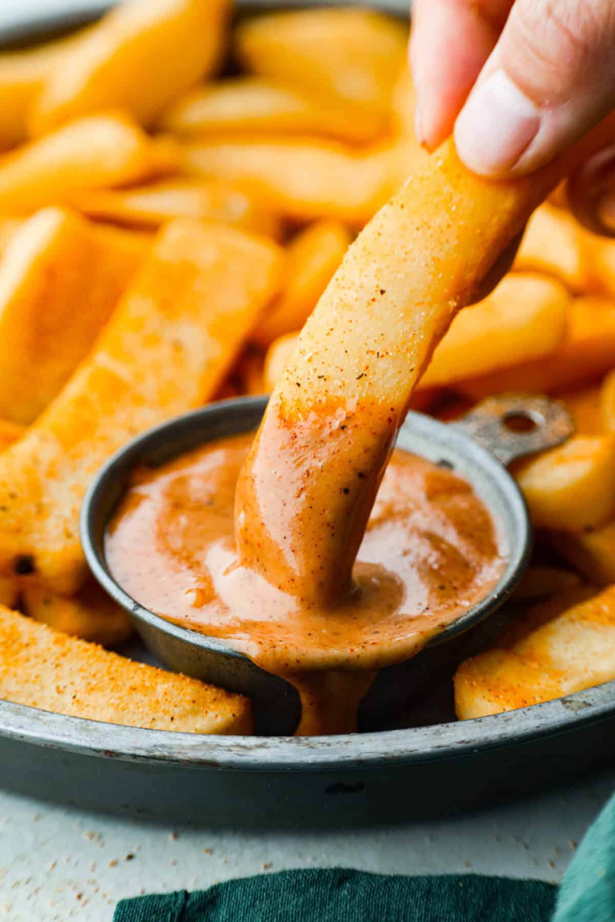 Red Robin campfire sauce is the best pairing for your burgers, fries, and more. Whip it up in minutes with just 4 ingredients and enjoy the deliciously creamy consistency and smoky flavor. Close up shot of someone dipping a fry into a small bowl of re robin campfire sauce.