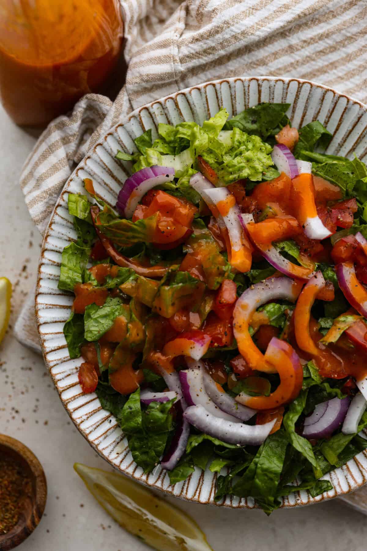 Delicious Catalina French Dressing will give your salad the perfect tangy, sweet flavor! It comes together quickly with a few simple ingredients you probably already have in your kitchen! Once you try it, you will want to have it on repeat! Overhead shot of plated salad with Catalina French dressing drizzled over the top.
